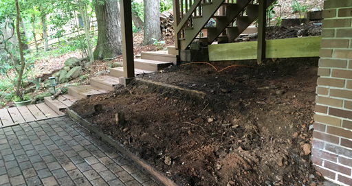 Uncared for under-stairs area, a rough dirt slope